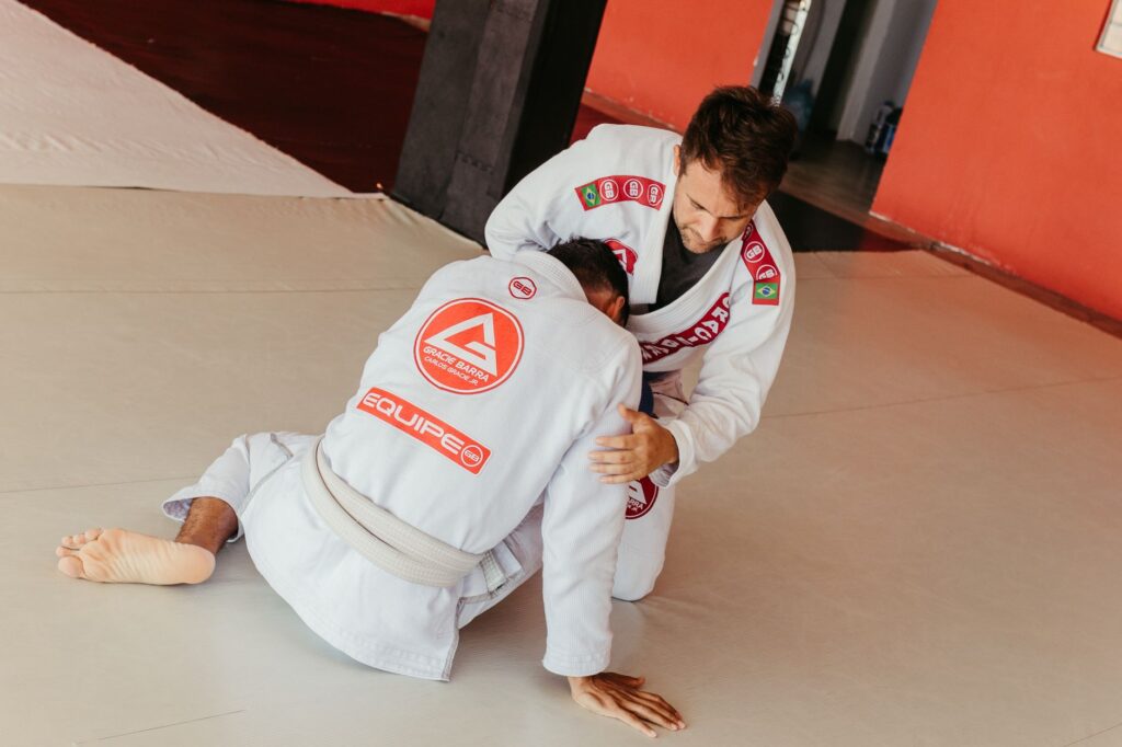 Gi grapplers working from a seated front-control exchange