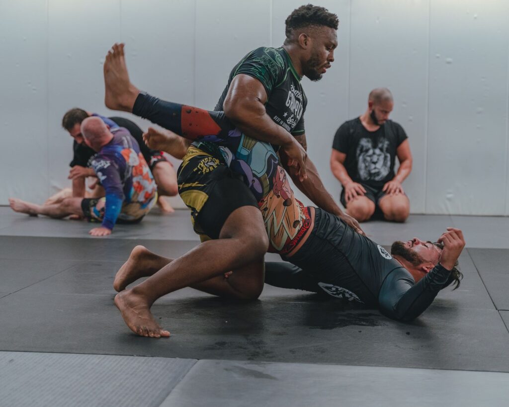 No-gi athletes training leg-control positions in a grappling class