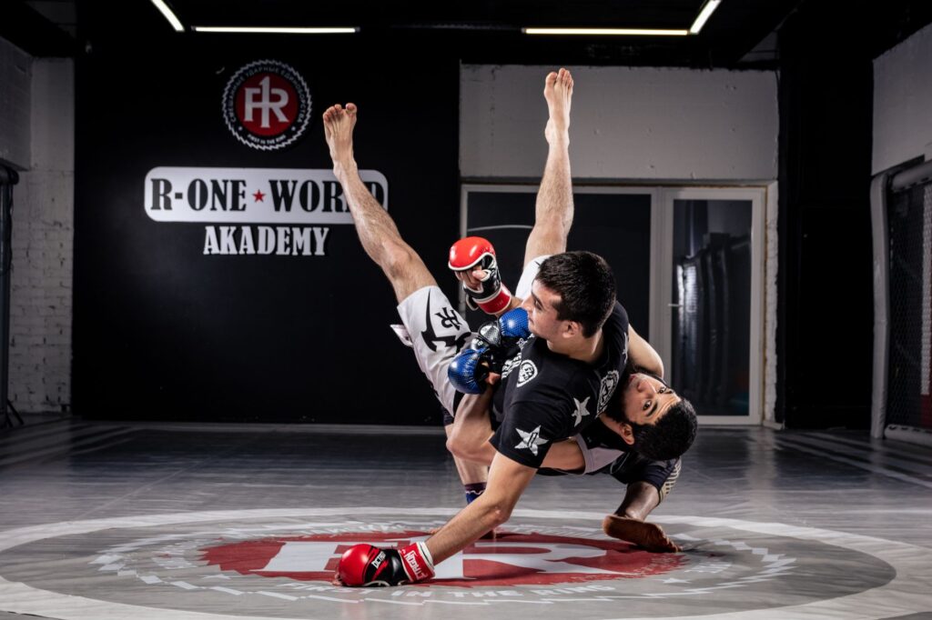Adult martial artists practicing an off-balancing takedown