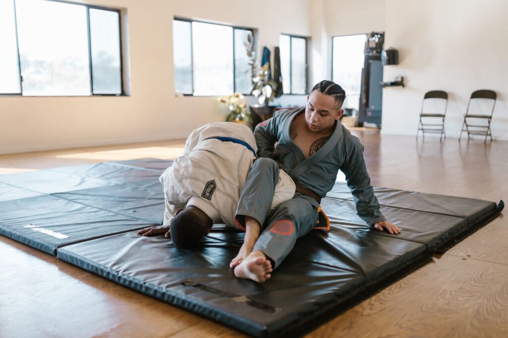 Gi grapplers drilling a controlled leg-entanglement position