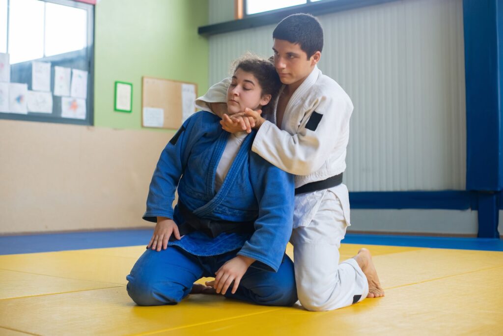 Adult martial artists practicing rear control and defensive hand positioning