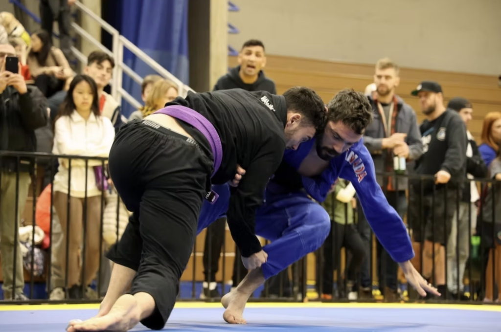 Brian O'Connor competing in a Brazilian Jiu-Jitsu gi tournament, shooting for a takedown