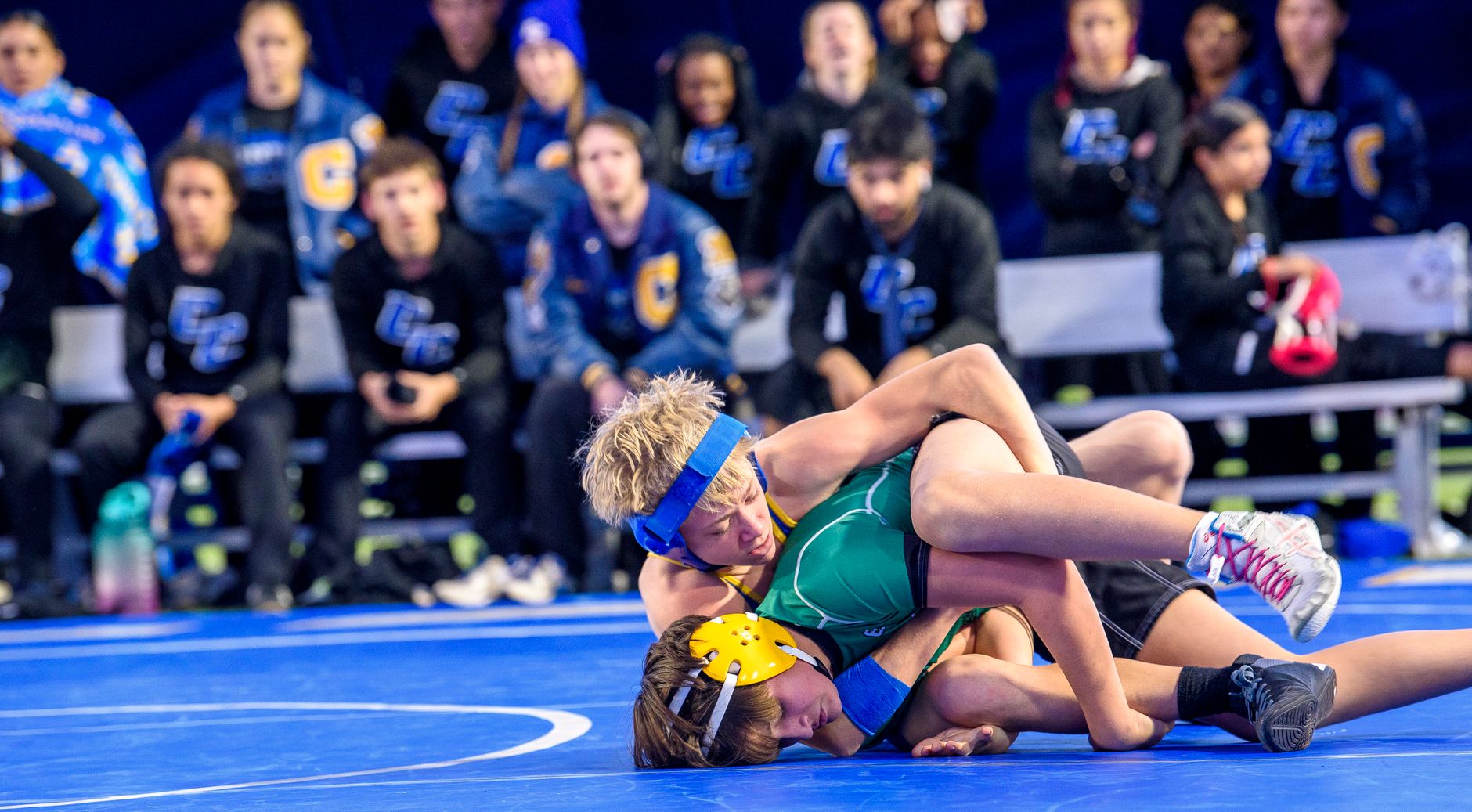 Wrestler in top control working for a pin during an amateur folkstyle wrestling match