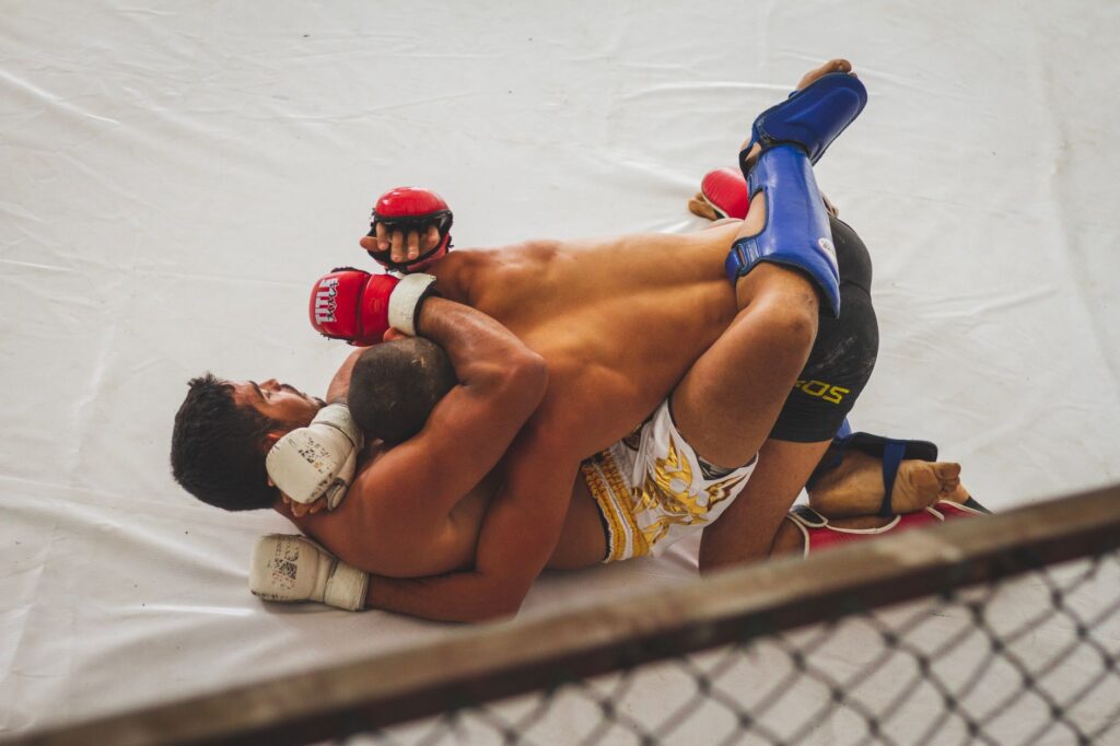Amateur MMA fighters grappling on the ground with one controlling from top position