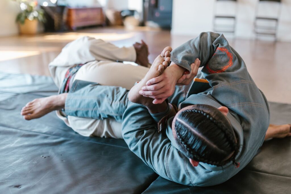 Adult Brazilian jiu-jitsu partners practicing a guard exchange