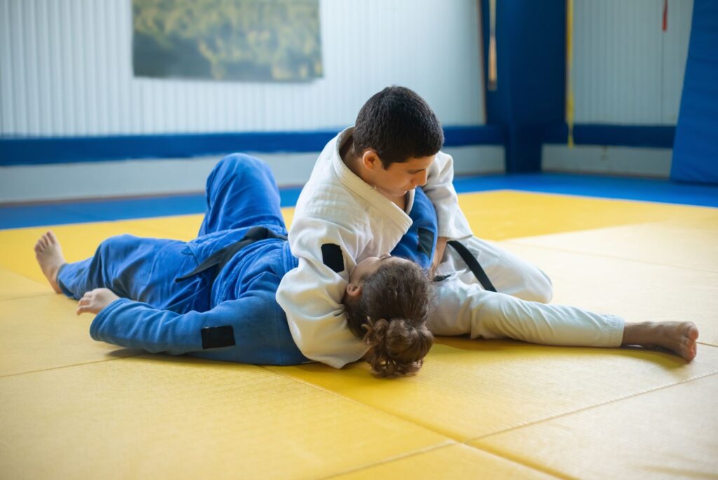 Adult gi grapplers drilling a grounded reversal sequence