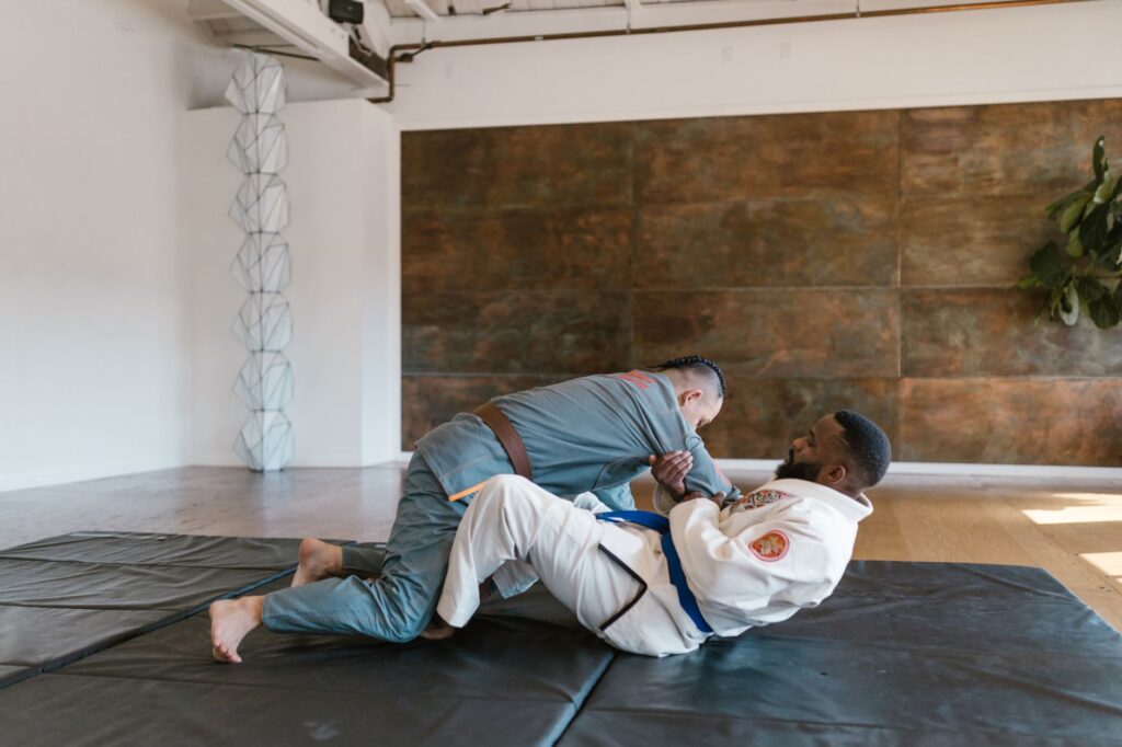 Adult grapplers practicing a grounded position during gi training