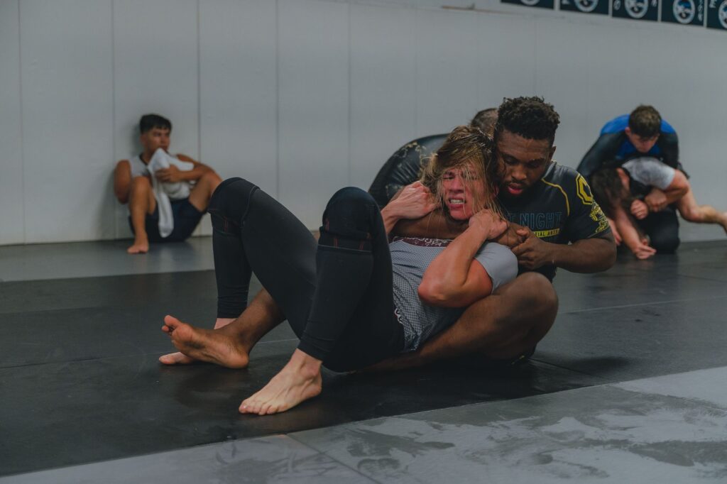 Adult no-gi grapplers practicing seated guard movement
