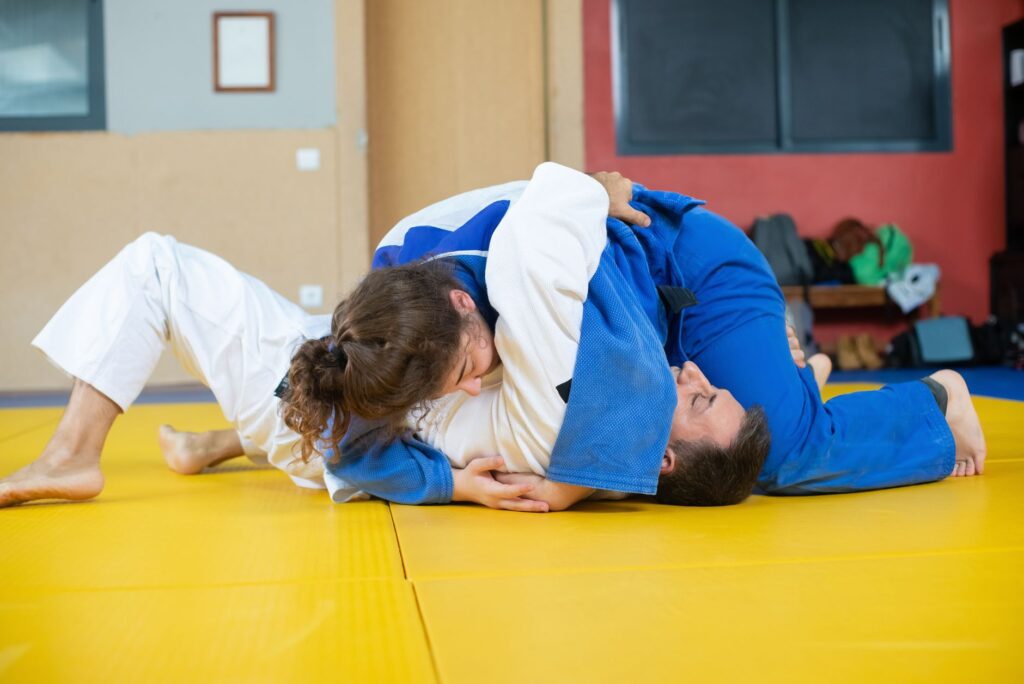 Adult gi partners practicing grounded movement and top control