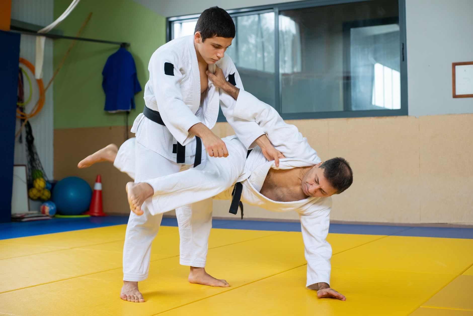 A judoka throwing a partner during judo training on a tatami mat