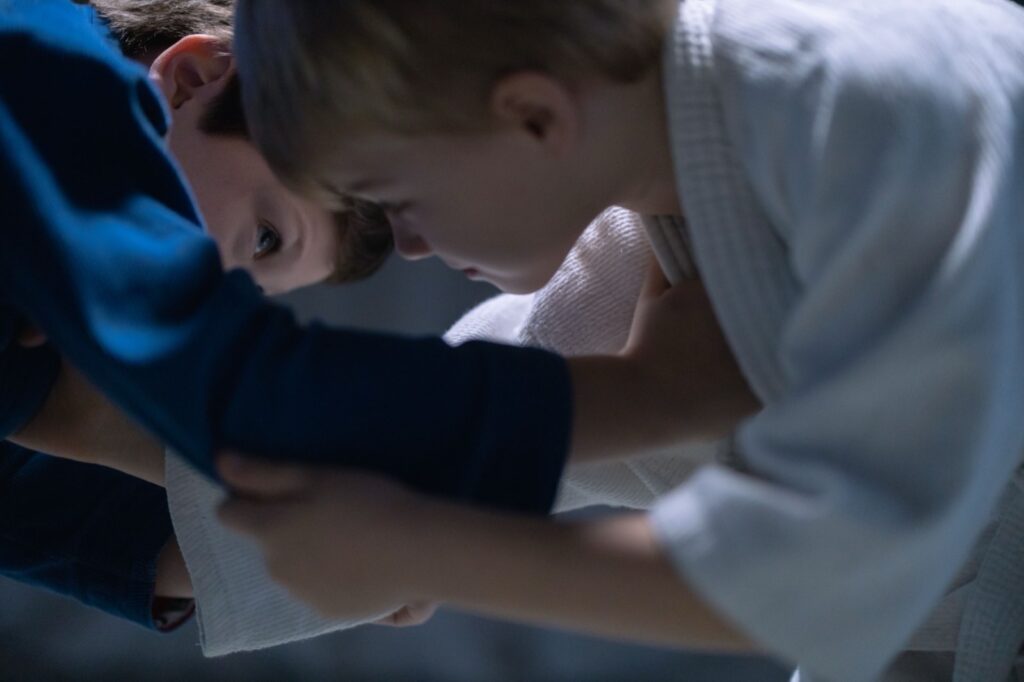 Two young BJJ competitors grip fighting in blue and white gis