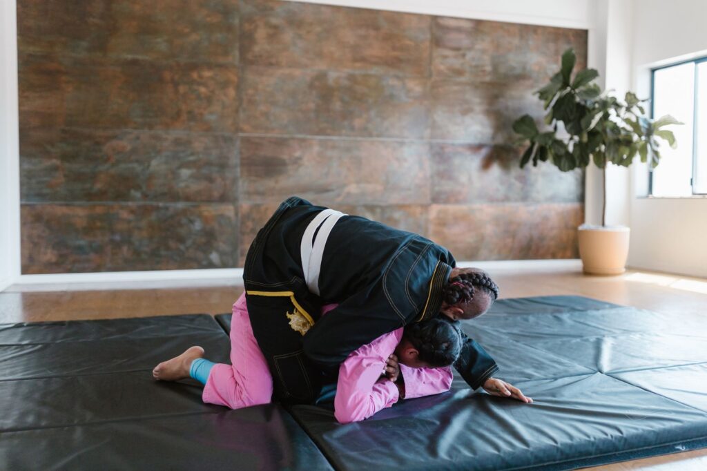Gi grapplers training from a top-control position