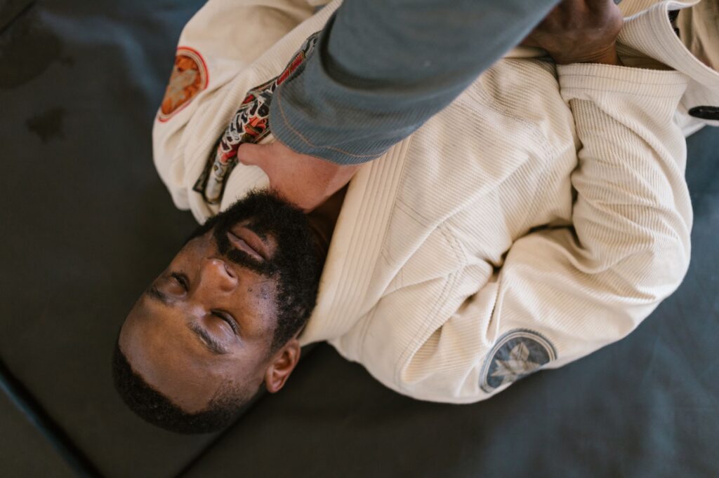Adult gi grapplers practicing a dynamic grounded transition