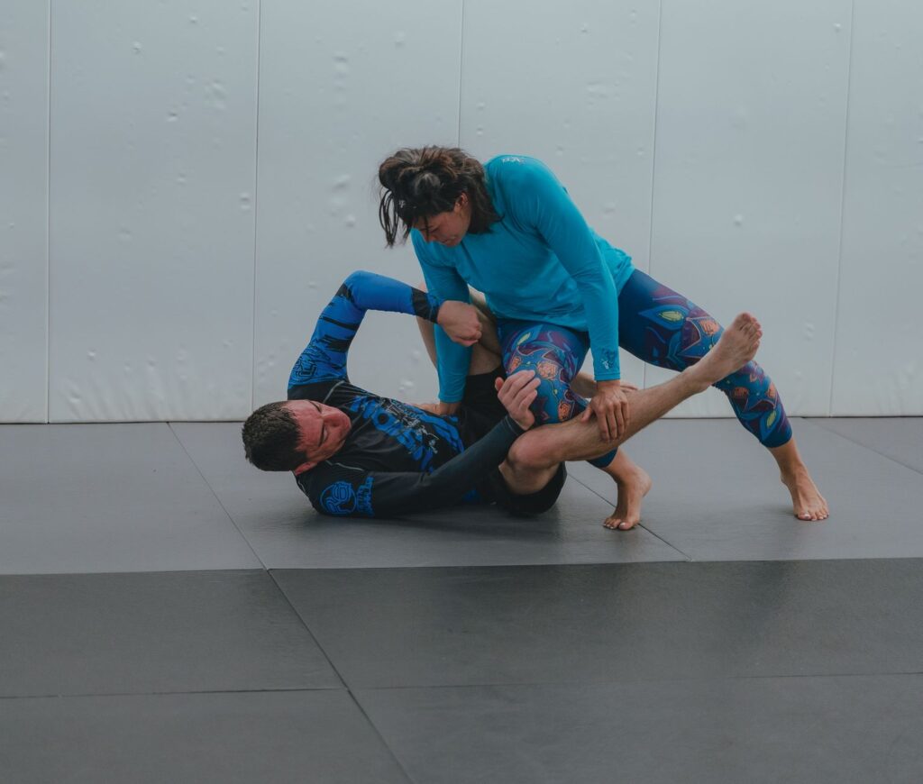 Adult no-gi grapplers working a ground escape during training