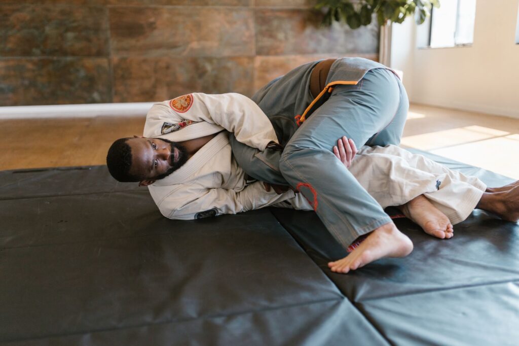 Two adult grapplers working a top-control position on training mats