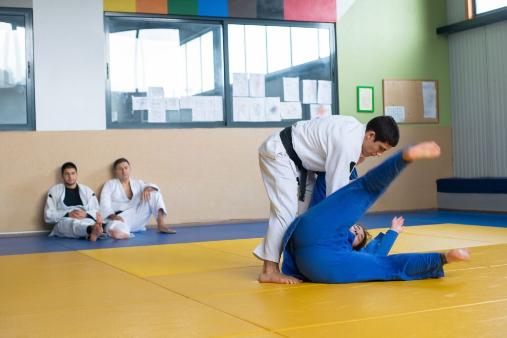Adult martial artists training a standing-versus-grounded exchange
