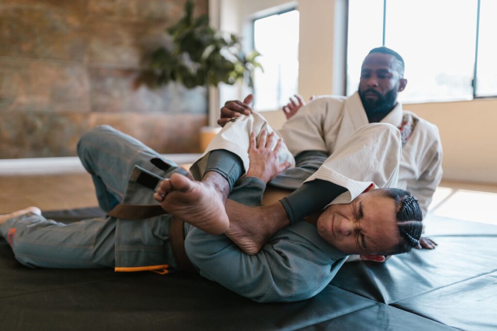 Gi grapplers practicing a lower-body control exchange