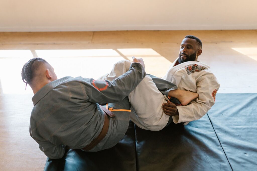 Adult gi grapplers working with frames and leg position on the mat