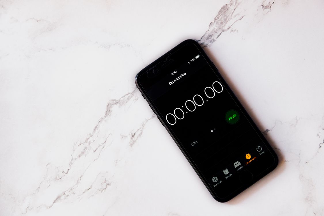 Smartphone showing a stopwatch at zero on a marble surface.